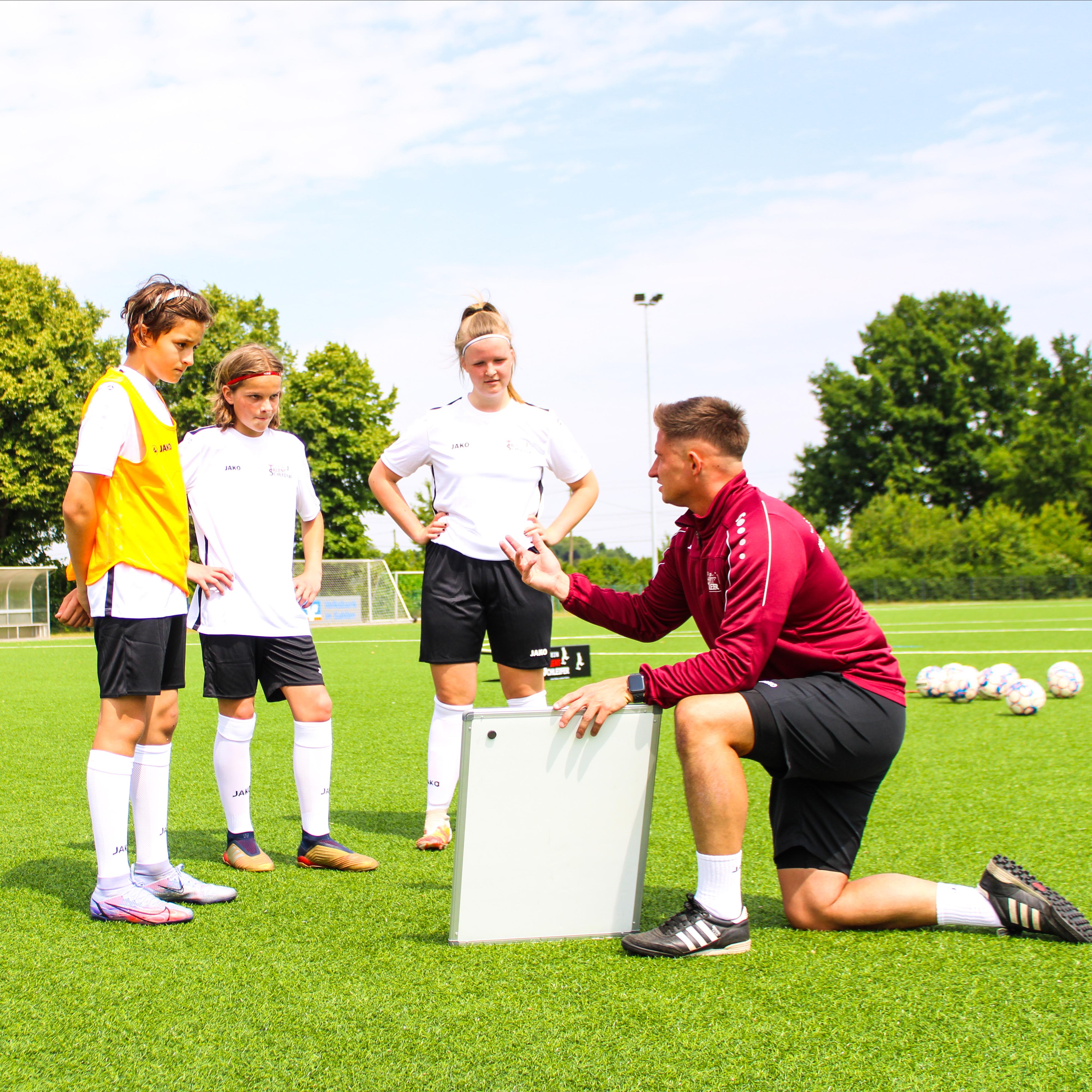 Trainer mit Spielern bei der Erklärung der Übungen